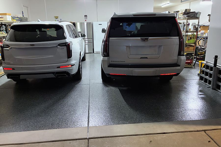 Two SUVs parked on a finished dark flake epoxy garage floor